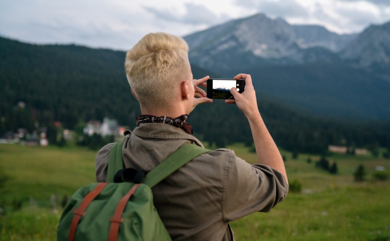 young man with backpack taking a photo on the top 2021 08 28 22 15 48 utc